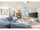 Cozy living room featuring a stone fireplace, vaulted ceilings, and scenic window views at 900 Sawmill Creek Rd, Evergreen, CO 80439