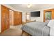 Comfortable main bedroom featuring a rustic log bed, large TV, and access to an outdoor deck at 900 Sawmill Creek Rd, Evergreen, CO 80439