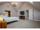 A cozy bedroom with white comforter, chandelier, and TV at 1751 Clermont St, Denver, CO 80220