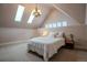 A cozy bedroom with white comforter, chandelier, and skylights at 1751 Clermont St, Denver, CO 80220