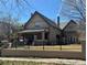 Charming two-story home featuring a well-maintained lawn and secure black metal fence at 1751 Clermont St, Denver, CO 80220