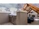 Stylish outdoor kitchen area featuring stainless steel appliances, brick accents, and a covered seating space with fireplace at 1751 Clermont St, Denver, CO 80220