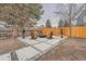 Backyard patio with Adirondack chairs and fire pit, surrounded by a wood fence and trees at 4055 S Niagara Way, Denver, CO 80237