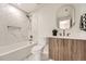 Stylish bathroom featuring marble tile, a modern vanity, and bathtub-shower combo at 4055 S Niagara Way, Denver, CO 80237