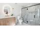 Bright bathroom features a wood vanity, oval mirror, and glass-enclosed shower at 4055 S Niagara Way, Denver, CO 80237