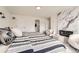 A bright bedroom with a modern fireplace, soft chairs and a stylish striped comforter at 4055 S Niagara Way, Denver, CO 80237
