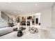 A large living room opens to a contemporary kitchen with light wood floors and staircase at 4055 S Niagara Way, Denver, CO 80237