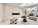 Modern living room with a marble accent wall, electric fireplace, and ample natural light from a skylight at 4055 S Niagara Way, Denver, CO 80237
