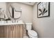 Elegant powder room featuring modern vanity, a stylish mirror, and neutral wall color at 4055 S Niagara Way, Denver, CO 80237