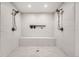Luxurious walk-in shower featuring dual shower heads, marble-like tile surround, and integrated bench seating at 4055 S Niagara Way, Denver, CO 80237