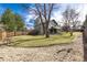 Large backyard featuring a well-maintained lawn, mature trees and a wood fence at 8025 S Cody St, Littleton, CO 80128
