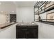 Basement bar area with a stone fireplace, bar seating, a sink, and a storage rack at 8025 S Cody St, Littleton, CO 80128