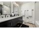 Dual vanity bathroom featuring dual mirrors, sleek counter tops, and wooden floor at 8025 S Cody St, Littleton, CO 80128