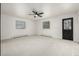 Bedroom featuring a ceiling fan, two windows, light colored carpet, and black interior doors at 8025 S Cody St, Littleton, CO 80128