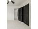 Bedroom with neutral carpet, ceiling fan, and black closet doors at 8025 S Cody St, Littleton, CO 80128