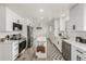 Modern kitchen features white cabinets, stainless steel appliances, quartz countertops, and an island at 8025 S Cody St, Littleton, CO 80128