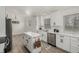 Modern kitchen features white cabinets, stainless steel appliances, quartz countertops, and an island at 8025 S Cody St, Littleton, CO 80128