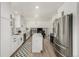 Modern kitchen features white cabinets, stainless steel appliances, and a center island, seamlessly connecting to the living space at 8025 S Cody St, Littleton, CO 80128