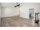 Bright, open living room boasts hardwood floors, vaulted ceilings, ceiling fan, and stairs to upper level at 8025 S Cody St, Littleton, CO 80128