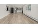 Open floor plan showcasing hardwood floors, a black door, and connecting kitchen area, creating a spacious and inviting atmosphere at 8025 S Cody St, Littleton, CO 80128