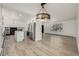Open-concept living area with hardwood floors, modern lighting, and kitchen view, creating a welcoming and spacious atmosphere at 8025 S Cody St, Littleton, CO 80128