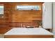 Bright bathroom showcasing a modern soaking tub with wood paneling, minimalist fixtures, and a floating cabinet at 1452 S Washington St, Denver, CO 80210