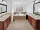 Bright bathroom with double vanity sinks, a soaking tub, and neutral tile flooring at 2180 Trailblazer Way, Castle Rock, CO 80109