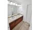Bathroom with a double vanity featuring two sinks and neutral colored tile flooring at 2180 Trailblazer Way, Castle Rock, CO 80109