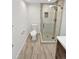 Modern bathroom featuring a tiled glass shower, commode, and wood-look tile flooring at 2180 Trailblazer Way, Castle Rock, CO 80109