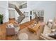 Bright, staged living room with high ceilings, wood floors, staircase, and adjoining dining room at 2180 Trailblazer Way, Castle Rock, CO 80109