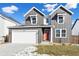 Two-story farmhouse-style home with gray siding, red door, and a white garage at 9324 Quartz St, Arvada, CO 80007