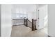 Hallway view with wood railing, carpeted floor, and natural light from windows at 9324 Quartz St, Arvada, CO 80007