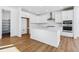 Bright, all-white kitchen with stainless steel appliances, a spacious island, and hardwood floors at 9324 Quartz St, Arvada, CO 80007