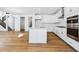 Modern kitchen with stainless steel appliances, island, and adjoining living area and staircase at 9324 Quartz St, Arvada, CO 80007