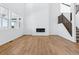 Bright living room with tall ceilings, large windows, fireplace, wood floors, and stairs at 9324 Quartz St, Arvada, CO 80007