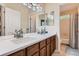 Bright bathroom with double sink vanity, modern lighting, and access to the commode at 16341 Maple Rock Ct, Parker, CO 80134