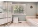 Bright bathroom with a glass-enclosed shower, a soaking tub, and a large window for natural light at 16341 Maple Rock Ct, Parker, CO 80134
