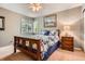 Cozy bedroom featuring a wood frame bed, matching nightstand, and large window views at 16341 Maple Rock Ct, Parker, CO 80134