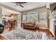 Open-concept living area with large windows, hardwood floors, and a fireplace adjacent to the kitchen at 16341 Maple Rock Ct, Parker, CO 80134