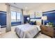 This bright bedroom features a large window and chic decor for a serene space to relax at 4108 Estrella St, Brighton, CO 80601