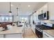 Modern kitchen with a large island, white cabinets, stainless steel appliances, and an open floor plan at 4108 Estrella St, Brighton, CO 80601