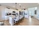 Modern kitchen featuring white cabinets, stainless steel appliances, a large island with bar seating, and ample lighting at 4108 Estrella St, Brighton, CO 80601
