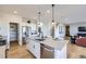Bright kitchen with white cabinets, stainless steel appliances, and an island with seating, open to the living area at 4108 Estrella St, Brighton, CO 80601