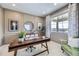 Stylish home office with a modern desk, decorative accents, and a large window providing natural light at 4108 Estrella St, Brighton, CO 80601