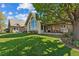 Lush backyard featuring a stone-clad home with expansive windows and a well-manicured lawn at 5101 Saint Vrain Rd, Longmont, CO 80503