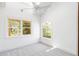 Bright bedroom featuring a vaulted ceiling, fan, carpet, and two windows that let in natural light at 5101 Saint Vrain Rd, Longmont, CO 80503