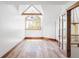 Bright bonus room featuring hardwood floors, arched window, and a wood beam accent at 5101 Saint Vrain Rd, Longmont, CO 80503