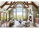 Bright living room with vaulted ceilings, exposed beams, stone fireplace, and expansive windows at 5101 Saint Vrain Rd, Longmont, CO 80503