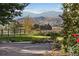 Scenic property view with rolling hills, rustic fencing, and vibrant landscaping at 5101 Saint Vrain Rd, Longmont, CO 80503