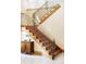 Elegant wooden staircase with decorative iron railings and a wooden cabinet on the side at 5101 Saint Vrain Rd, Longmont, CO 80503